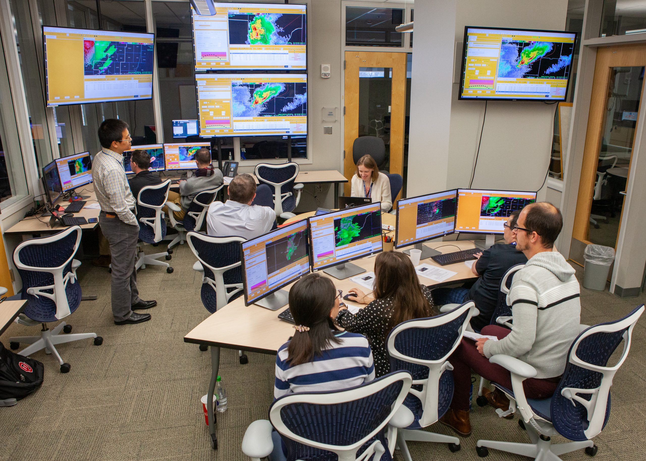 Researchers and forecasters testing new forecasting technologies on a computer screen.